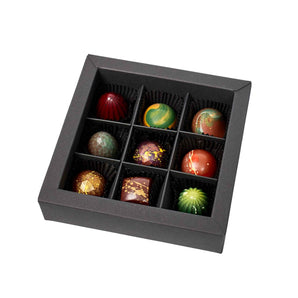 Bunte Pralinenbox mit verschiedenen handgemachten Pralinen in Zartbitter, Vollmilch und Weißer Schokolade