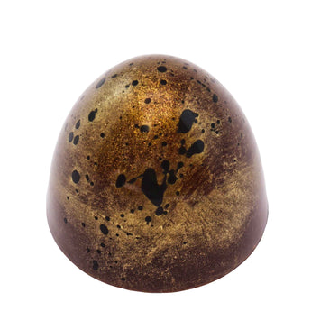 Handgemachte Praline mit Karamell, Nougat und einer Haselnuss